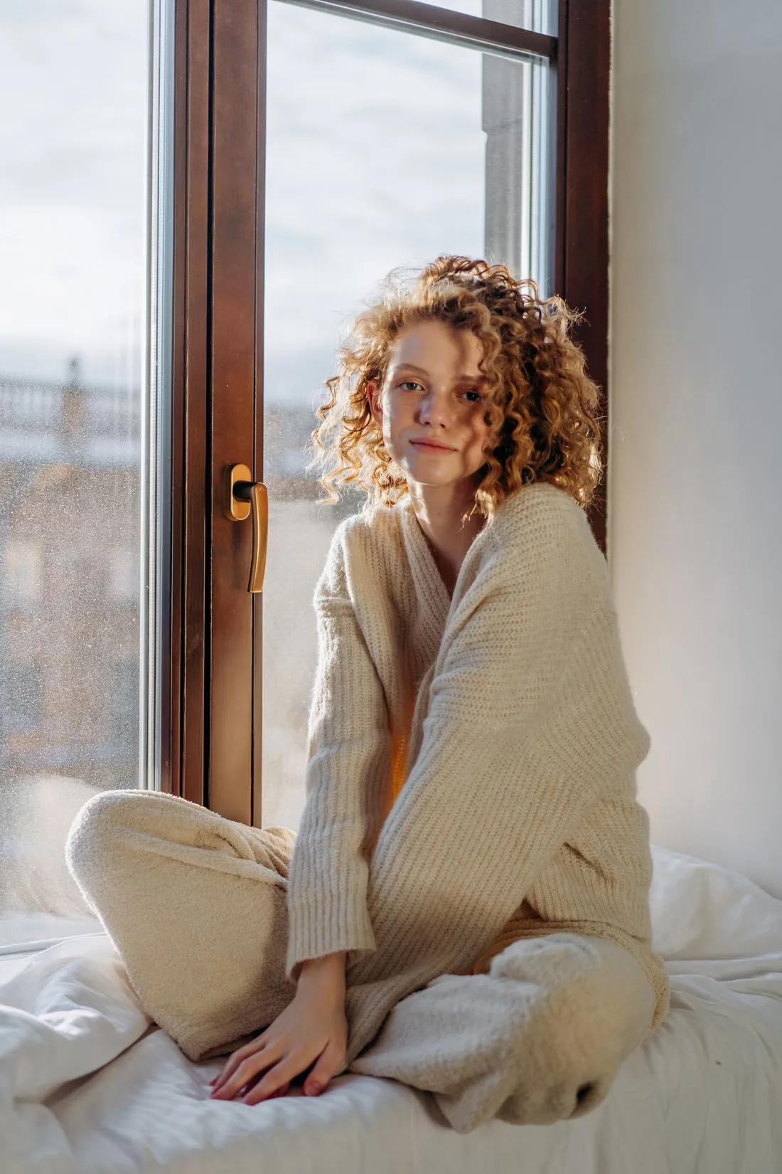 Woman relaxing at home in a cream knit lounge set